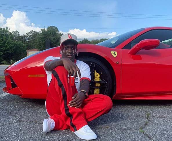 Lil Yachty taking a picture side by side of his Ferrari car.